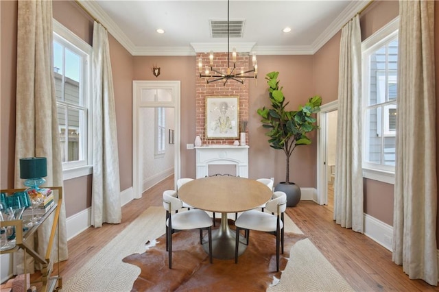 4119 S Liberty St, New Orleans, LA 70115 - dining area with healthy amount of natural light, light wood finished floors, a chandelier, baseboards, and crown molding