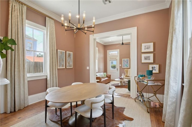 4119 S Liberty St, New Orleans, LA 70115 - dining space featuring light wood-type flooring, crown molding, healthy amount of natural light, and a chandelier
