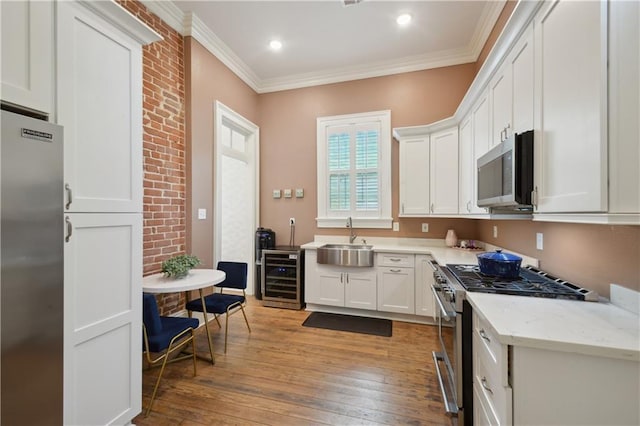 4119 S Liberty St, New Orleans, LA 70115 - kitchen featuring stainless steel appliances, wine cooler, a sink, light wood finished floors, and white cabinets