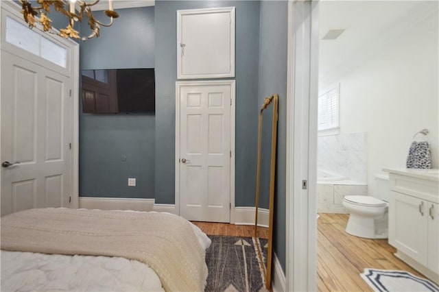 4119 S Liberty St, New Orleans, LA 70115 - bedroom with a chandelier, light wood-style floors, ensuite bath, and baseboards