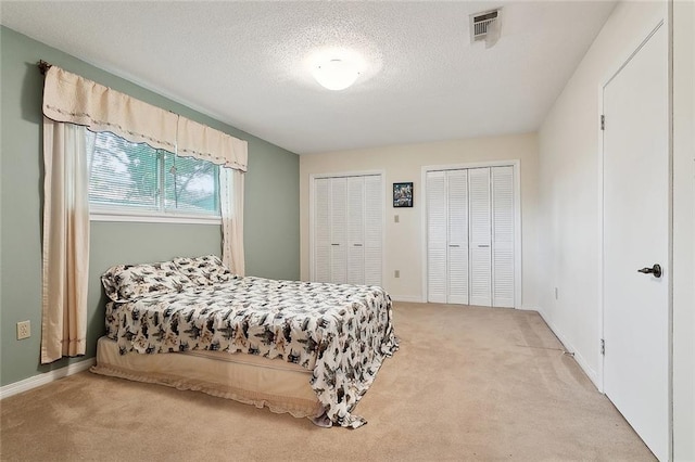 1508 Apple St, Metairie, LA 70001 - bedroom featuring light carpet, multiple closets, baseboards, and a textured ceiling