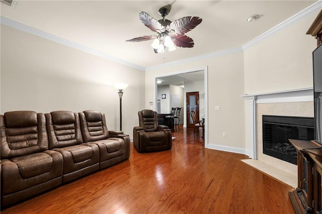 40145 Taylor Trl Unit 503, Slidell, LA 70461 - living room with a ceiling fan, ornamental molding, wood finished floors, a tiled fireplace, and baseboards