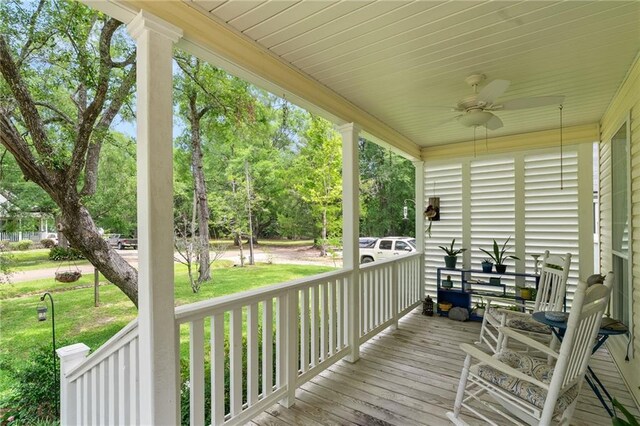 22236 8th St, Abita Springs, LA 70420 - wooden porch with ceiling fan, a lawn, and view of scattered trees