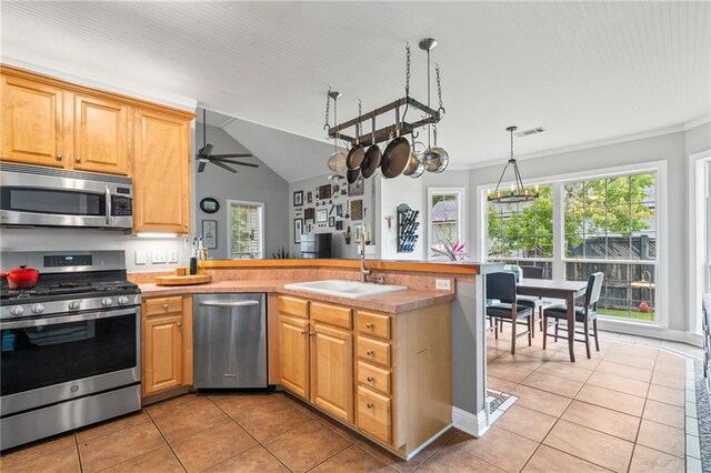 22236 8th St, Abita Springs, LA 70420 - kitchen with appliances with stainless steel finishes, light tile patterned flooring, a peninsula, healthy amount of natural light, and ornamental molding