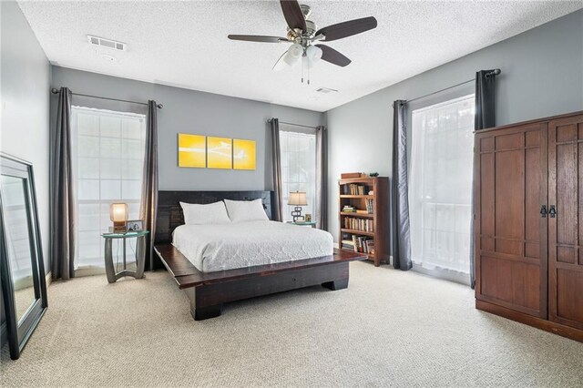 22236 8th St, Abita Springs, LA 70420 - bedroom featuring light carpet, multiple windows, a textured ceiling, and ceiling fan