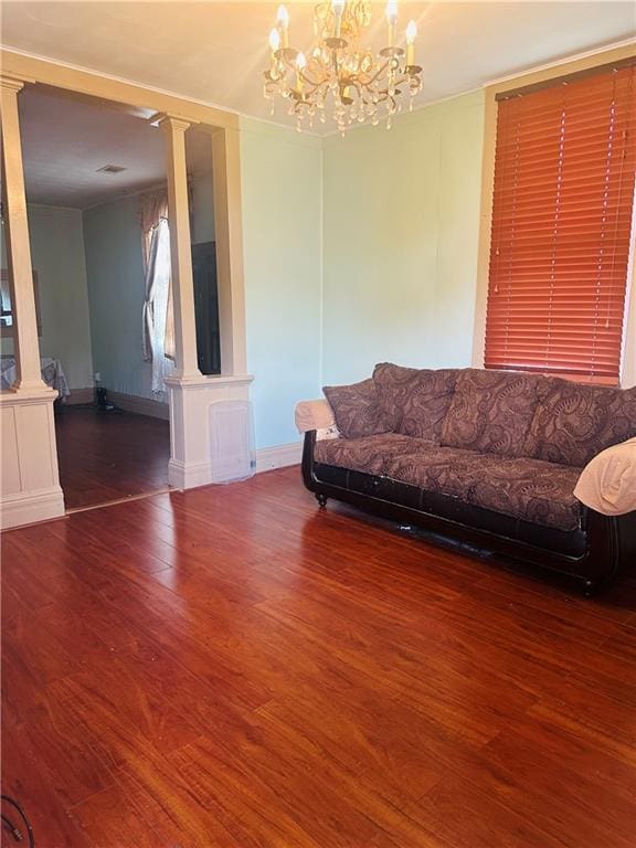 307 Diana St, New Orleans, LA 70114 - living room with ornate columns, wood finished floors, a chandelier, and baseboards
