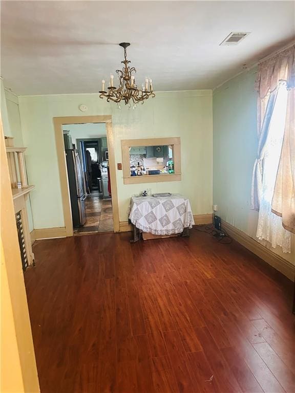 307 Diana St, New Orleans, LA 70114 - bedroom with wood finished floors, a chandelier, freestanding refrigerator, and baseboards