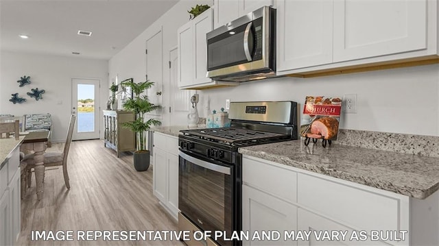 311 Holmes Blvd, Terrytown, LA 70056 - kitchen with appliances with stainless steel finishes, light wood-type flooring, white cabinets, light stone counters, and recessed lighting