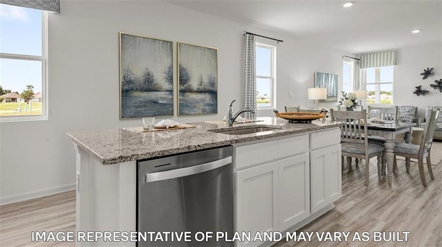 311 Holmes Blvd, Terrytown, LA 70056 - kitchen featuring stainless steel dishwasher, a sink, light wood-style flooring, light stone counters, and white cabinetry