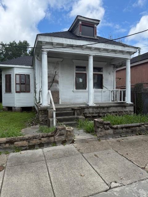 5123 Chartres St, New Orleans, LA 70117 - greek revival house with a porch and roof with shingles