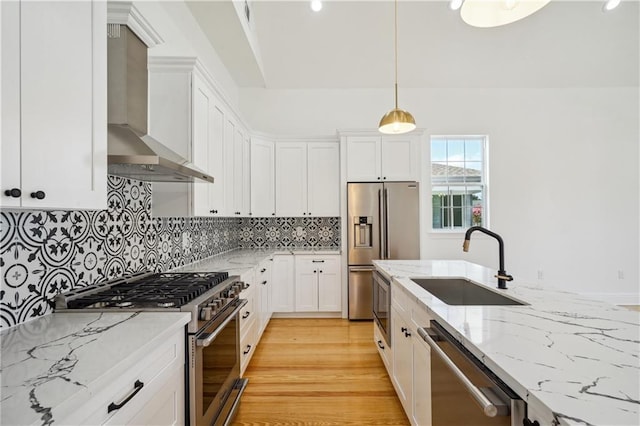 5519 Wingate Dr, New Orleans, LA 70122 - kitchen featuring stainless steel appliances, wall chimney range hood, white cabinets, light stone counters, and recessed lighting