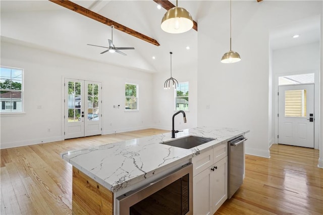 5519 Wingate Dr, New Orleans, LA 70122 - kitchen featuring high vaulted ceiling, beamed ceiling, light wood finished floors, pendant lighting, and white cabinetry