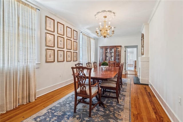 317 Henry Clay Ave, New Orleans, LA 70118 - dining space featuring a chandelier, ornamental molding, wood finished floors, and baseboards