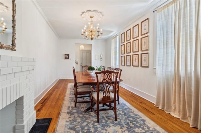 317 Henry Clay Ave, New Orleans, LA 70118 - dining space featuring a chandelier, wood finished floors, baseboards, and crown molding