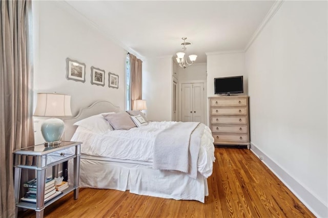 317 Henry Clay Ave, New Orleans, LA 70118 - bedroom with crown molding, a chandelier, wood finished floors, a closet, and baseboards