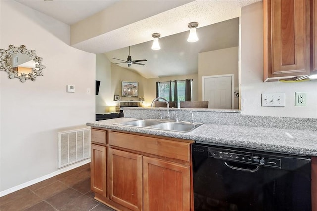 kitchen featuring dishwasher, a sink, ceiling fan, brown cabinets, and dark tile patterned floors