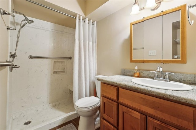 full bathroom featuring a shower stall, vanity, and toilet