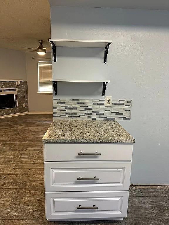 detailed view of wood finished floors, a fireplace, and baseboards
