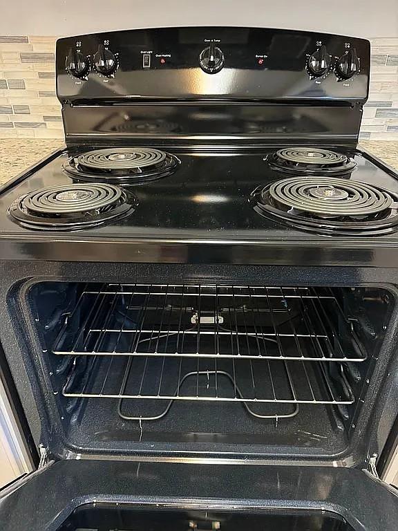 kitchen view of black electric range and backsplash