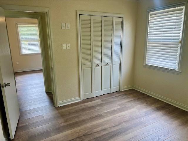 817 N Sibley St, Metairie, LA 70003 - unfurnished bedroom with baseboards, a closet, and wood finished floors