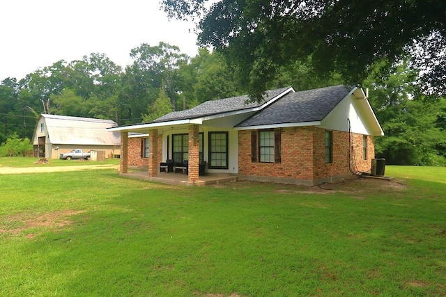 42073 Farlow Ln, Ponchatoula, LA 70454 - back of house with a yard, central AC, brick siding, and roof with shingles