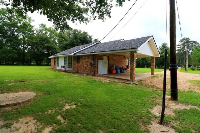 42073 Farlow Ln, Ponchatoula, LA 70454 - back of house featuring a yard, brick siding, a patio area, and roof with shingles