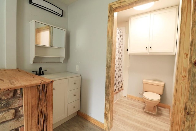 42073 Farlow Ln, Ponchatoula, LA 70454 - full bath featuring wood finished floors, toilet, curtained shower, baseboards, and vanity