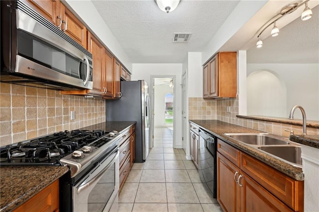 2228 Veronica Dr, Chalmette, LA 70043 - kitchen with appliances with stainless steel finishes, a sink, brown cabinetry, a textured ceiling, and ceiling fan