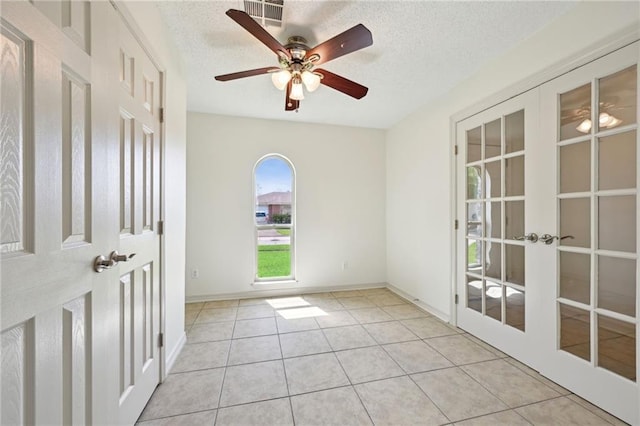2228 Veronica Dr, Chalmette, LA 70043 - tiled empty room featuring french doors, a textured ceiling, ceiling fan, and baseboards