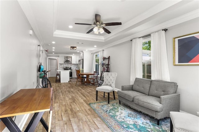 2067 Lafreniere St, New Orleans, LA 70122 - living room featuring light wood-type flooring, crown molding, recessed lighting, ceiling fan, and a tray ceiling