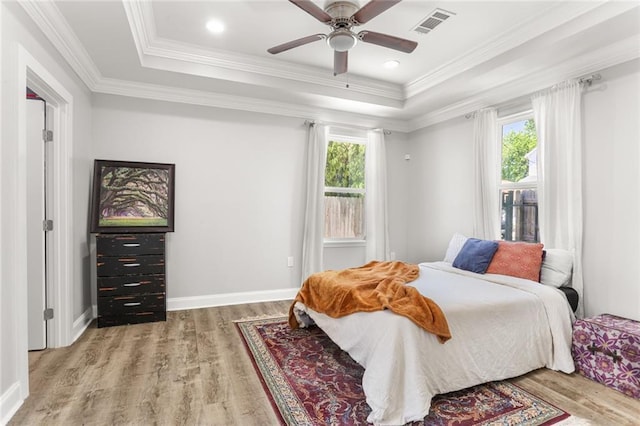2067 Lafreniere St, New Orleans, LA 70122 - bedroom with a raised ceiling, multiple windows, wood finished floors, and ornamental molding
