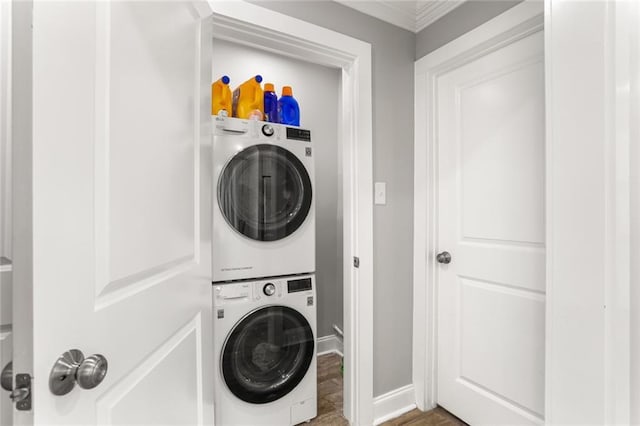2067 Lafreniere St, New Orleans, LA 70122 - laundry area featuring stacked washing machine and dryer, ornamental molding, and baseboards