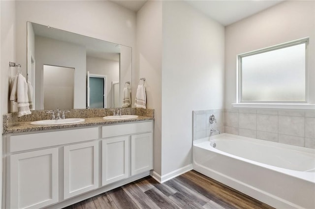784 Bent Cypress Ln, Slidell, LA 70461 - bathroom with a garden tub, wood finished floors, double vanity, and baseboards
