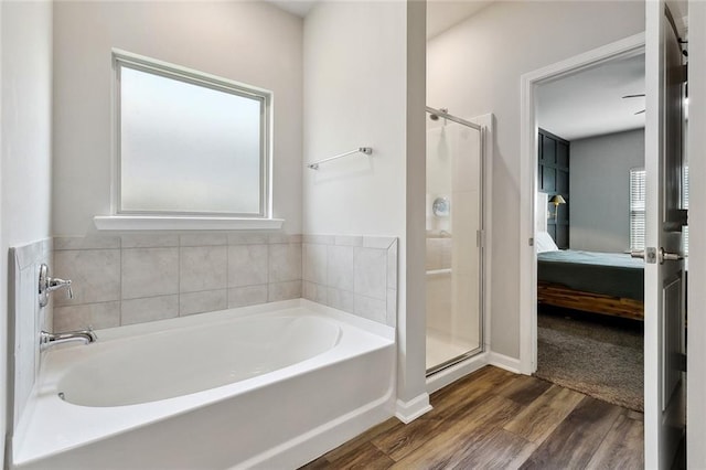 784 Bent Cypress Ln, Slidell, LA 70461 - bathroom with ensuite bathroom, a bath, wood finished floors, a shower stall, and baseboards