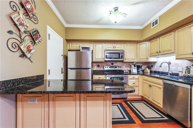 1750 Saint Charles Ave Unit 505, New Orleans, LA 70130 - kitchen featuring stainless steel appliances, a sink, a peninsula, a textured ceiling, and crown molding