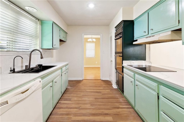 5927 Brighton Pl, New Orleans, LA 70131 - kitchen featuring black appliances, a sink, under cabinet range hood, light countertops, and baseboards
