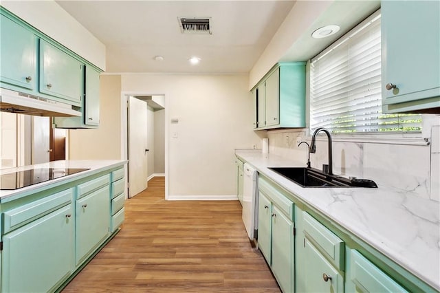 5927 Brighton Pl, New Orleans, LA 70131 - kitchen with under cabinet range hood, green cabinets, black electric cooktop, a sink, and light countertops