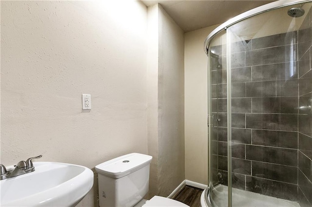 5927 Brighton Pl, New Orleans, LA 70131 - bathroom with a sink, a shower stall, toilet, wood finished floors, and baseboards
