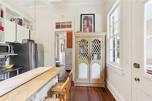 919 Robert St, New Orleans, LA 70115 - kitchen featuring stainless steel appliances, dark wood-style floors, open shelves, a kitchen breakfast bar, and ornamental molding
