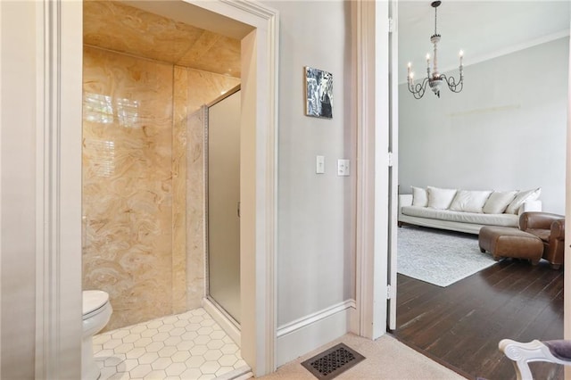 919 Robert St, New Orleans, LA 70115 - bathroom featuring a chandelier, a stall shower, toilet, and connected bathroom
