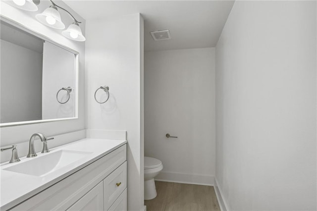 48 Bleu Lake Dr, Covington, LA 70435 - bathroom with wood finished floors, toilet, vanity, and baseboards