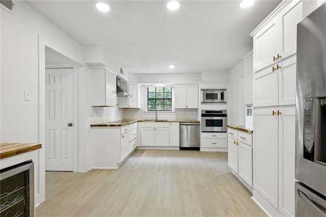 48 Bleu Lake Dr, Covington, LA 70435 - kitchen featuring stainless steel appliances, beverage cooler, light wood-type flooring, decorative backsplash, and recessed lighting