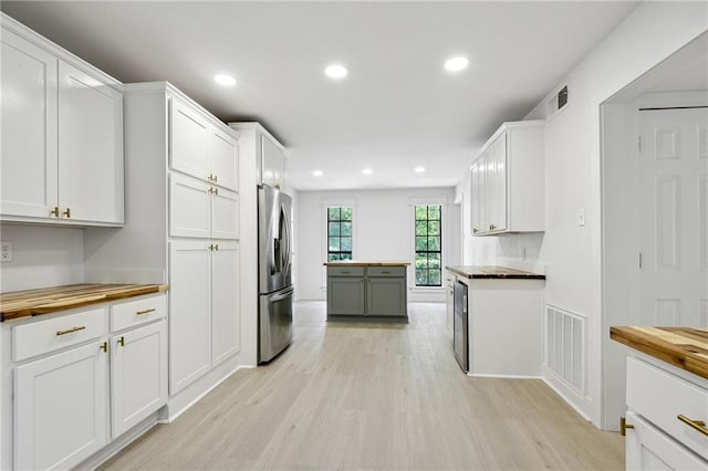 48 Bleu Lake Dr, Covington, LA 70435 - kitchen with wooden counters, stainless steel refrigerator with ice dispenser, light wood-type flooring, white cabinets, and recessed lighting