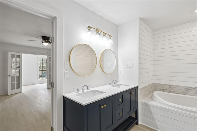 48 Bleu Lake Dr, Covington, LA 70435 - bathroom featuring ceiling fan, wood finished floors, a tub, and double vanity