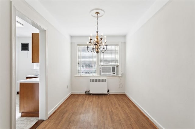 5402 St Charles Ave, New Orleans, LA 70115 - unfurnished dining area with radiator, a chandelier, wood finished floors, baseboards, and cooling unit