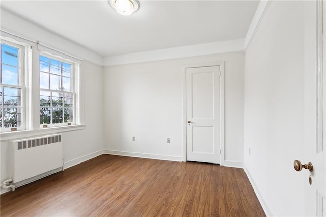 5402 St Charles Ave, New Orleans, LA 70115 - empty room featuring radiator, wood finished floors, and baseboards