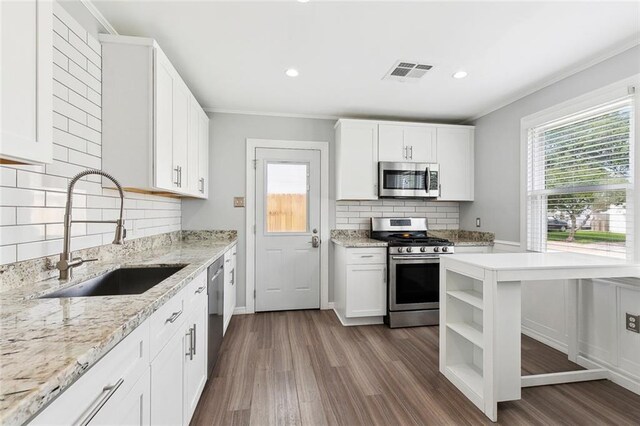 313 Harang Ave, Metairie, LA 70001 - kitchen with appliances with stainless steel finishes, a sink, open shelves, plenty of natural light, and ornamental molding