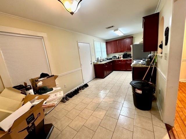 1742 4th St, Slidell, LA 70458 - kitchen featuring dark brown cabinets, ornamental molding, light tile patterned flooring, and light countertops