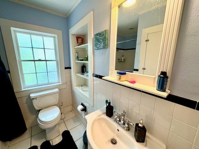 1742 4th St, Slidell, LA 70458 - full bath with toilet, crown molding, tile patterned floors, tile walls, and a sink