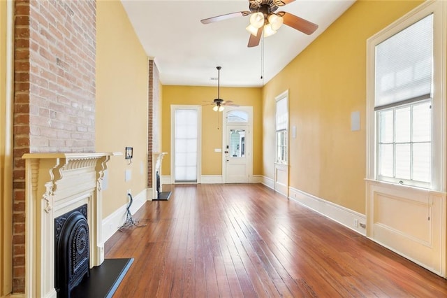 3119 Dauphine St, New Orleans, LA 70117 - entrance foyer with ceiling fan, a fireplace with raised hearth, healthy amount of natural light, and hardwood / wood-style flooring